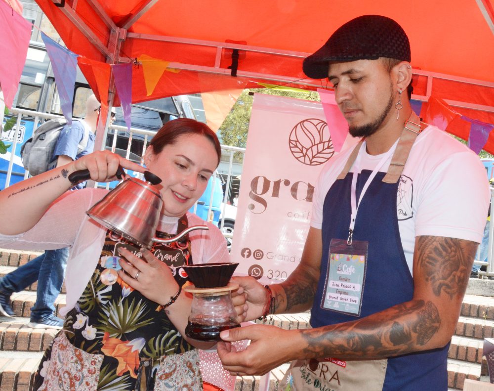 "El amor que depositan los caficultores en el grano debemos representarlo también como baristas y catadores", afirma Viviana Grand, quien atiende a los visitantes de la Feria de Café, Cultura y Tradición en el estand de Grand Coffee Shop, de Villamaría (Caldas), junto a Juan Federico Palacio.