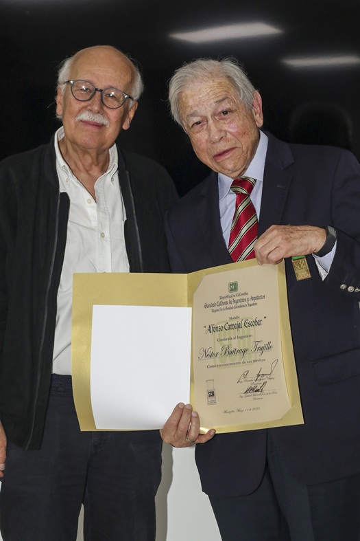 El ingeniero Nelson Arturo Mejía Ramírez hace entrega del diploma que lo exalta como socio honorario de la SCIA a Néstor Buitrago Trujillo.