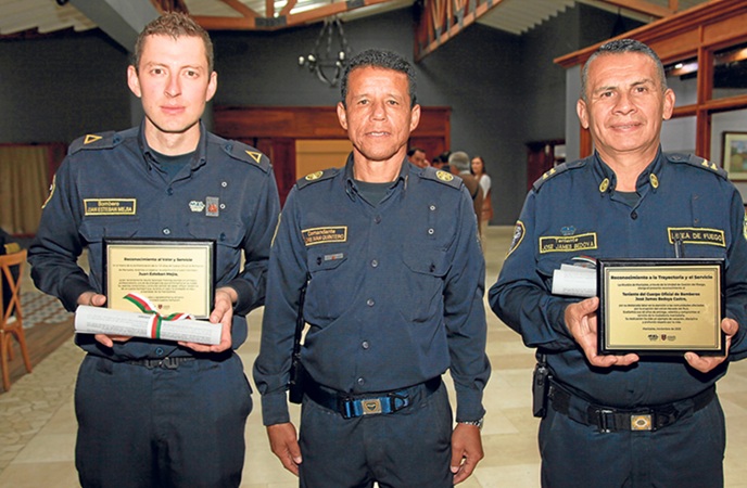 Reconocimiento a José James Bedoya Castro y Juan Esteban Mejía Aristizábal. Los acompaña en la imagen Jorge Iván Quintero, comandante del Cuerpo de Bomberos de Manizales.