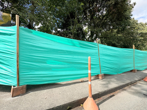 Una lona verde cubre el muro que será intervenido.