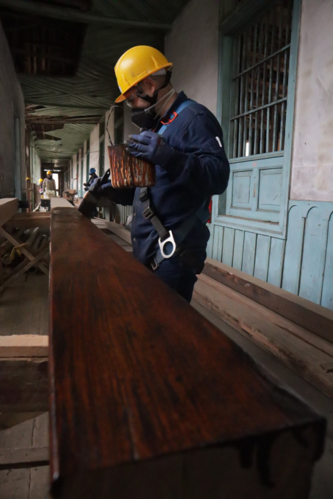 Trabajador pintando madera en la Juan XXIII