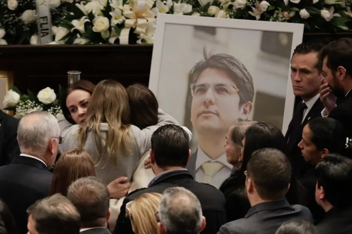 Fotografía de archivo de la esposa del fallecido senador y precandidato a la presidencia de Colombia Miguel Uribe Turbay, Claudia Tarazona, que abraza a sus hijas frente a una fotografía de Miguel, en el Salón Elíptico del Capitolio Nacional en Bogotá. 