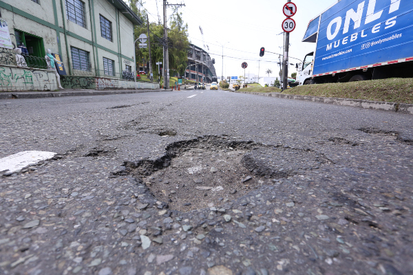 Ubicado en la mitad de la vía en el carril sentido Estadio-Centro, es esquivado por los vehículos que arrancan del semáforo del escenario deportivo. 