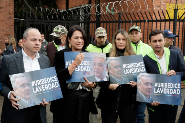 Simpatizantes del expresidente colombiano Álvaro Uribe sostienen carteles de apoyo este lunes, frente a los juzgados de Paloquemao en Bogotá (Colombia). 