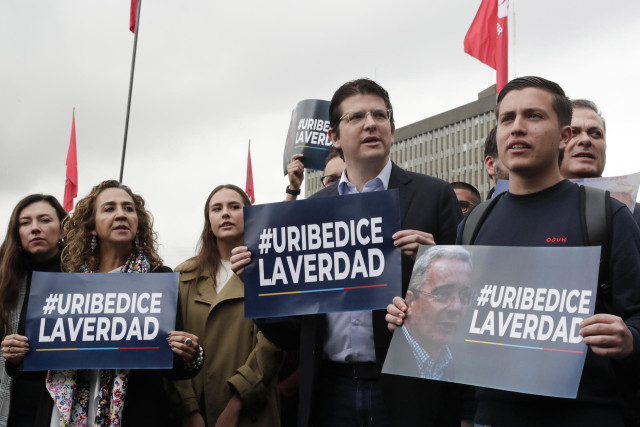 Simpatizantes del expresidente colombiano Álvaro Uribe sostienen carteles de apoyo este lunes, frente a los juzgados de Paloquemao en Bogotá (Colombia). 
