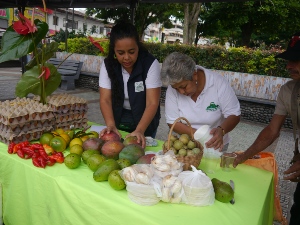Dos mujeres exhiben productos de campo en el Mercado Campesino de Chinchiná.