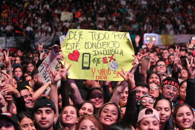 Foto | Luis Fernando Trejos | LA PATRIA La lluvia no impidió que las personas llegaran desde temprano para hacer la fila de ingreso al concierto. Llegaron con carteles rodeados de luces.