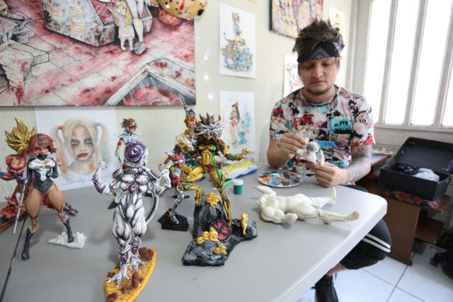 Alex Rivera junto con algunas de sus obras que tiene para exponer. Además de las pinturas y retratos que ha realizado.