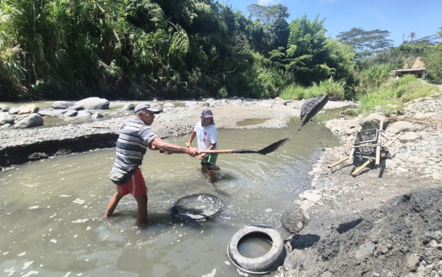 José y Uriel aún trabajan junto al río que un día los amenazó. Con palas y baldes se ganan su sustento dentro de la corriente que se llevó tantas vidas.