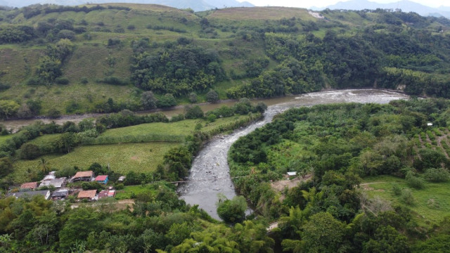 Vista aérea de la vereda El Retiro, donde se observa el río Chinchiná en su desembocadura en el río Cauca y el puente colgante que reemplazó al antiguo puente de hierro, arrastrado por la avalancha de 1985. 