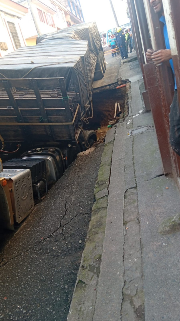 El vehículo avanzaba en contravía. Luego de ingresar por la calle 24, el camino cedió, se hundió con la tractomula y hubo daños en tubos de agua del sector.
