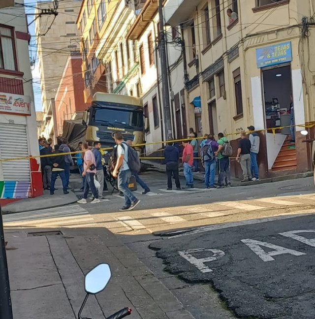 La vía está cerrada mientras las autoridades atienden el accidente. Una tractomula hundió una calle de Manizales y terminó enterrada. Estas son las imágenes.
