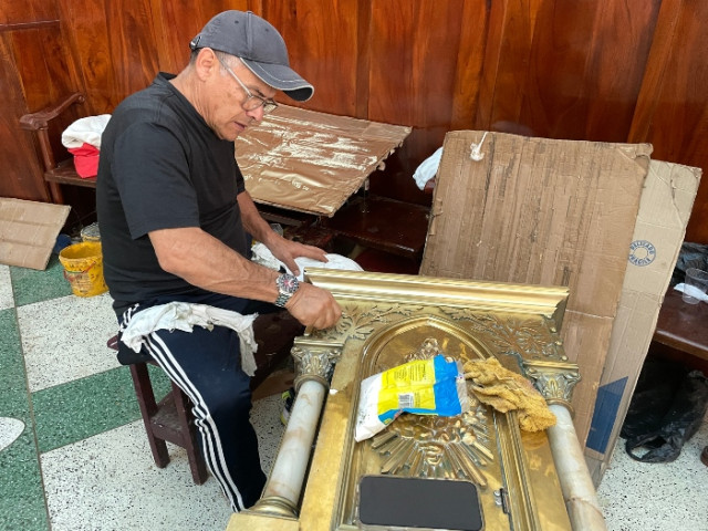 Momento en que el artista Augusto Concha restaura la tapa del sagrario.