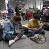 Personas esperan hoy, en el aeropuerto El Dorado de Bogotá (Colombia).   