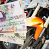 Mano sosteniendo billetes de pesos colombianos frente a varias motos.