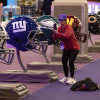 Una mujer toma una fotografía de cascos de fútbol de gran tamaño en la experiencia del Super Bowl en el Centro de Convenciones Mandalay Bay South en Las Vegas, Nevada, EE.UU.