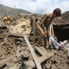 La gente rescata sus pertenencias de los escombros después de un terremoto en Afganistán.