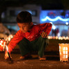 Un niño enciende velas durante la tradicional Noche de las Velitas este domingo, en Cali (Colombia). 