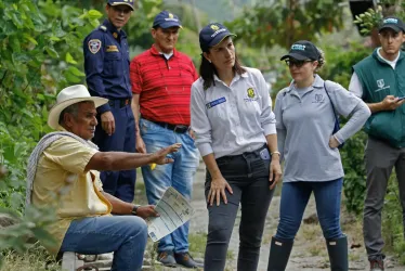 Funcionarios de la UGR (Unidad de Gestión del Riesgo) hablan con habitantes de la rivera del río Chinchiná, por donde bajaría el deshielo ante una posible erupción del volcán Nevado del Ruiz, este martes, en la vereda Llano Grande, cerca de Manizales.