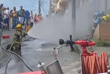 Bomberos controlan las llamas en la fachada de la casa en donde se presentó el incendio en La Linda. 