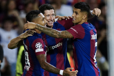 Raphinha, Robert Lewandowski y Joao Cancelo celebran uno de los cinco goles que el FC Barcelona le hizo al Royal Amberes en la primera fecha de la UEFA Champions League 2023-2024.