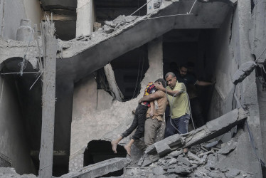 Un niño es rescatado de los escombros de un edificio residencial derribado por un ataque aéreo israelí, en el campo de refugiados de Jan Yunis, en el sur de la Franja de Gaza, este jueves.