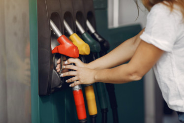 Foto gratuita elegante mujer de pie en una gasolinera