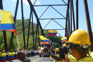 Asistentes observan al primer camión en cruzar el nuevo puente El Alambrado, conducido por Alfonso Medrano, presidente de la Cámara Intergremial del Transporte, quien atravesó la construcción a las 9:30 a. m. de ayer. El paso estuvo cerrado seis meses, luego del desplome del 12 de abril.