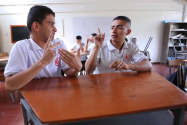 Los estudiantes sordos Daniel Felipe Soto, elegido personero, y Juan Diego Mejía, contralor, con su profesora de matemáticas, Ingrid Eliana Suárez, y la intérprete Yuri Alejandra González.