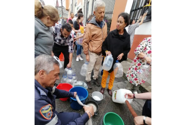 Habitantes del barrio Pinares del Río de Villamaría recolectan agua de un tanque de Bomberos.