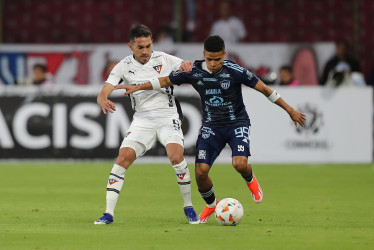 Lisandro Alzugaray (i) de LDU disputa el balón con José Enamorado de Junior este martes, en un partido de la fase de grupos de la Copa Libertadores entre LDU Quito y Junior en el estadio Rodrigo Paz Delgado en Quito (Ecuador).