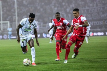 Once Gustavo Torres, del Once Caldas, trata de superar a dos rivales de Santa Fe, en el juego que ambos equipos empataron 0-0 anoche en el Palogrande. El Blanco sumó un punto, pero dejó escapar dos. La tabla se apretó porque Tolima le ganó a La Equidad y recuperó opciones.