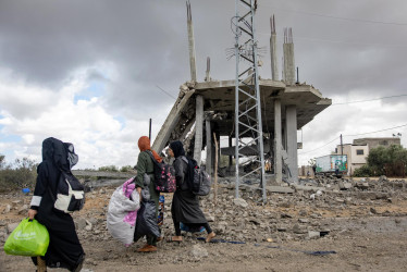 Mujeres palestinas desplazadas internamente cargan sus pertenencias tras una orden de evacuación emitida por el ejército israelí, en Rafah, sur de la Franja de Gaza, este lunes.