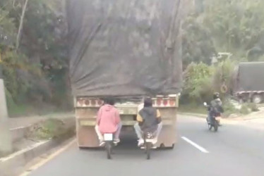 Cuatro jóvenes, montados en dos bicicletas, fueron captados en video sujetados de la parte trasera de un tractocamión en Manizales.