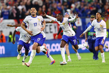 William Saliba (izq.) de Francia celebra con sus compañeros de equipo tras ganar la tanda de penaltis del partido de fútbol de cuartos de final de la Eurocopa 2024 entre Francia y Portugal, en Hamburgo (Alemania).