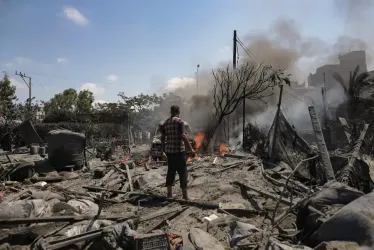 Varios palestinos inspeccionan la zona atacada en la zona de Al-Mawasi de Khan Yunis, en el sur de la Franja de Gaza. 