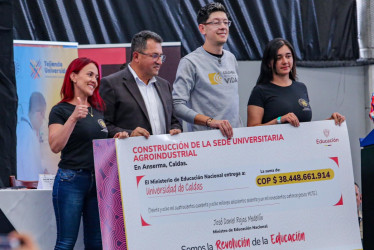 El rector de la Universidad de Caldas, Fabio Hernando Arias (izq.), y el ministro de Educación Nacional, Daniel Rojas, sostienen el cheque que certifica la inversión de $38 mil millones para la construcción de la sede agroindustrial de la institución en Anserma. Los acompañan las estudiantes Yeimi Quintero y Érika Sánchez.