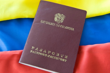 Pasaporte colombiano delante en la bandera