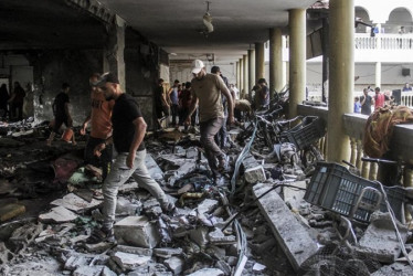 Palestinos inspeccionan los daños causados ​​por un ataque israelí contra la escuela Al-Taba'een en el barrio de Daraj Tuffah en Gaza. Foto EDH / EFE