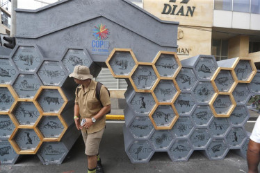 Un hombre observa una exposición de animales extintos en la Zona Verde durante la COP16 en Cali.