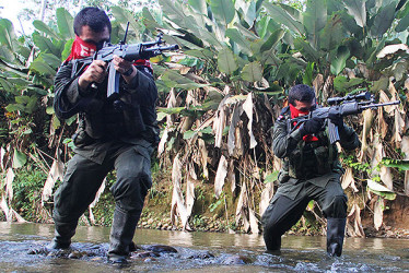 Integrantes del Eln apuntan con un arma en la selva.