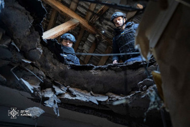 Rescatistas ucranianos retirando los restos de un cohete en el lugar de un edificio residencial dañado en Kiev, Ucrania. 