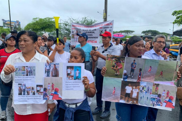Familiares de los cuatro menores ecuatorianos desaparecidos sostuvieron carteles durante un plantón en los exteriores de la Fiscalía de Guayaquil el martes 31 de diciembre, en Guayaquil (Ecuador).