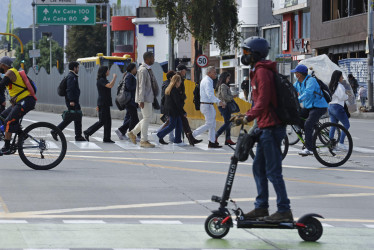 Personas caminan cerca a una estación de Transmilenio durante el 'día sin carro y sin moto' este jueves, en Bogotá.