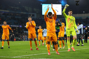 Brahim Díaz y sus compañeros del Real Madrid celebran ante los aficionados después de ganarle la ida de los play-offs de la Champions League al Manchester City en Inglaterra.