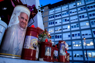  Una vela con la imagen del Papa Francisco, al pie de la estatua de San Juan Pablo II en las afueras del Hospital Universitario Gemelli, en Roma, donde el Papa Francisco se encuentra hospitalizado.