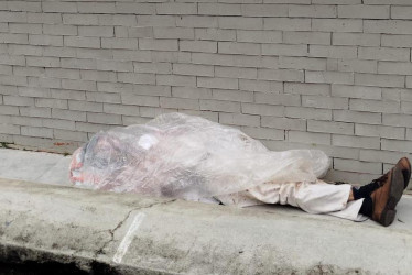 El adulto mayor acostado en un andén, a las afueras del Hospital San Vicente de Paúl de Anserma. 