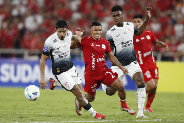 Cristian Barrios, del América, disputa un balón con Matheuzinho, de Corinthians, en el partido que colombianos y brasileños empataron 1-1 en Cali por la fecha 2 de la Copa Sudamericana.