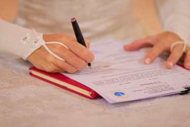 Novia firmando un certificado de matrimonio