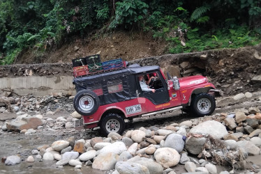 Carros, chivas y motos se han visto cruzando un río entre Caldas y Antioquia para desplazarse entre dos municipios que se quedaron sin vía el 11 de abril, por una creciente del caudal.